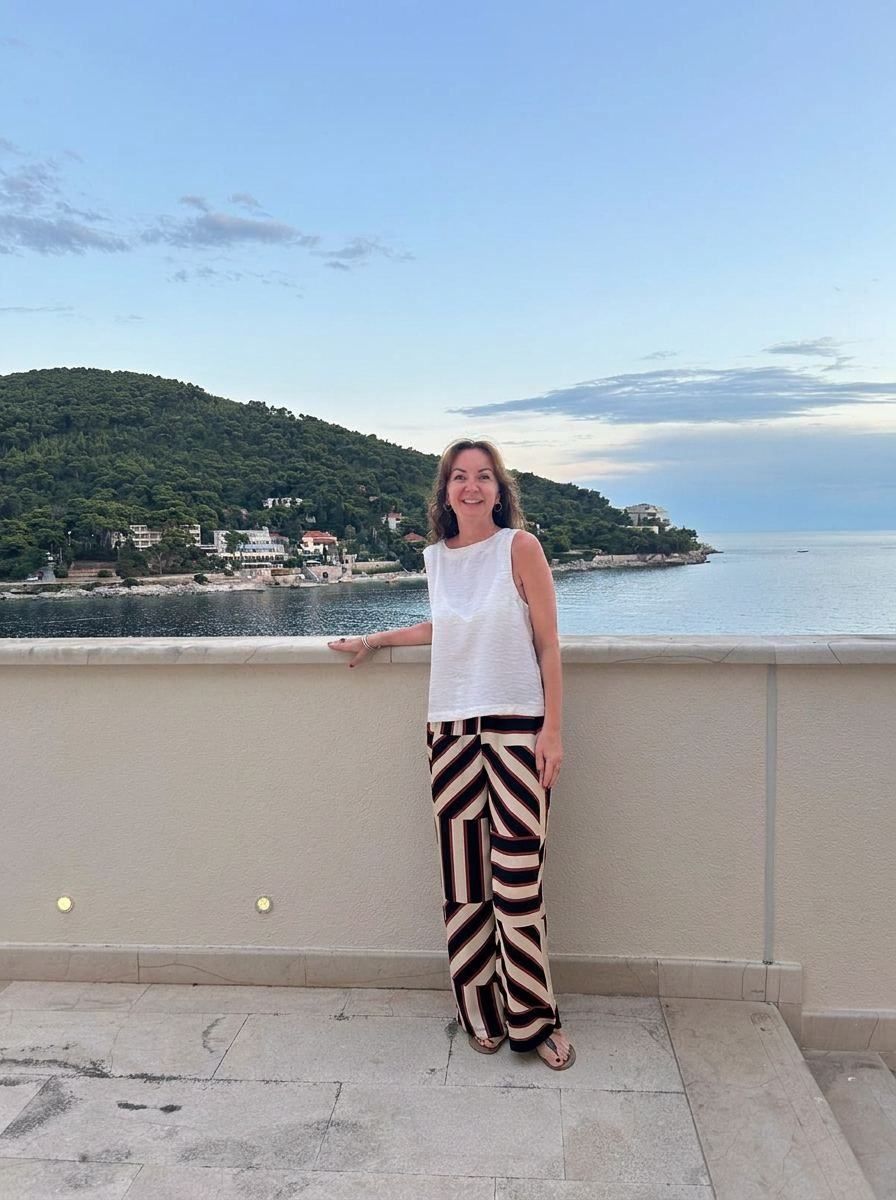 Catherine Daniels standing on a terrace overlooking the Adriatic in Dubrovnik at dusk